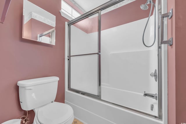 bathroom featuring shower / bath combination with glass door and toilet