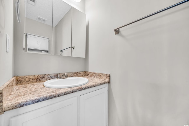 bathroom with vanity and a textured ceiling