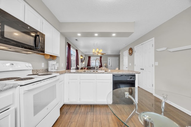 kitchen with white cabinetry, sink, kitchen peninsula, black appliances, and light wood-type flooring