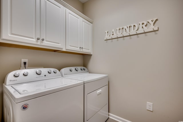 laundry room featuring washer and dryer and cabinets