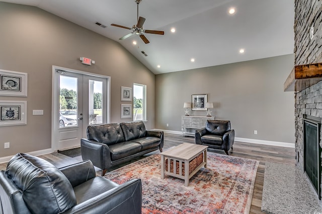 living room with high vaulted ceiling, french doors, ceiling fan, a fireplace, and wood-type flooring