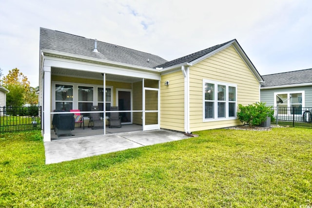 rear view of property featuring a patio area, a sunroom, and a yard