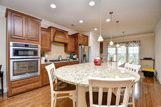 kitchen featuring stainless steel appliances, light hardwood / wood-style flooring, a spacious island, a kitchen bar, and custom exhaust hood