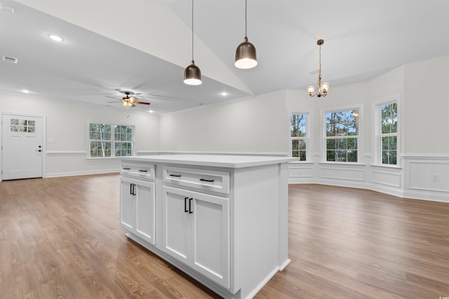 kitchen featuring white cabinetry, hanging light fixtures, light hardwood / wood-style floors, and a kitchen island