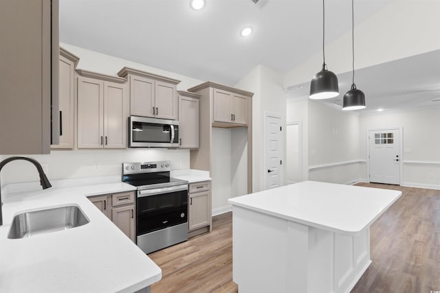 kitchen with appliances with stainless steel finishes, sink, hanging light fixtures, a center island, and light wood-type flooring