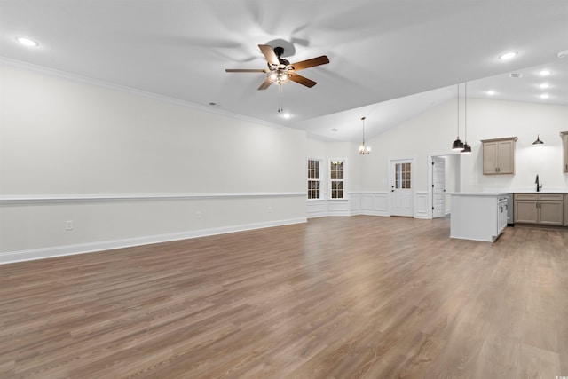 unfurnished living room featuring lofted ceiling, sink, ornamental molding, ceiling fan, and light hardwood / wood-style floors