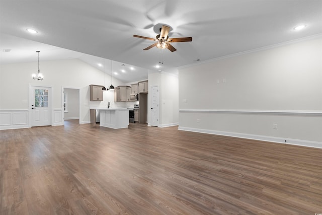 unfurnished living room featuring sink, dark wood-type flooring, ornamental molding, ceiling fan with notable chandelier, and vaulted ceiling