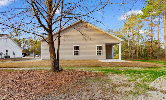 exterior space with central AC unit and a yard