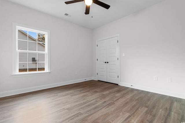 empty room with hardwood / wood-style floors and ceiling fan