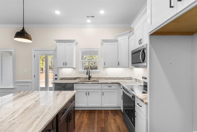 kitchen featuring white cabinetry, decorative light fixtures, light stone countertops, sink, and appliances with stainless steel finishes