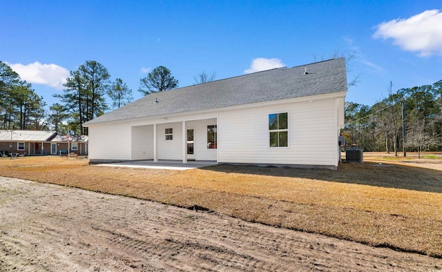 rear view of property with cooling unit, a lawn, and a patio area