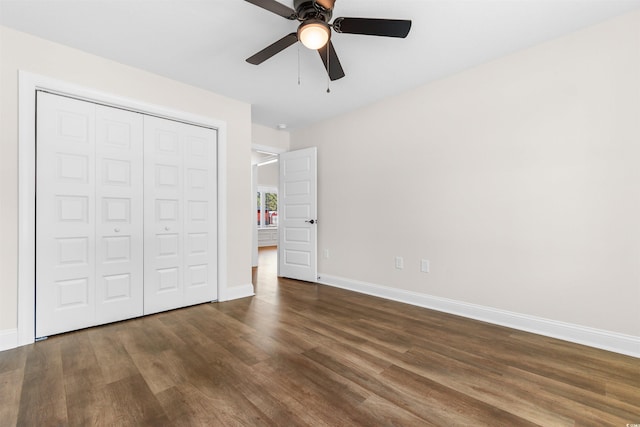 unfurnished bedroom with dark wood-type flooring, ceiling fan, and a closet