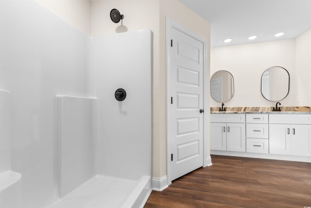 bathroom featuring vanity, a shower, and wood-type flooring