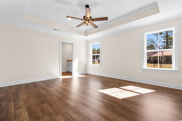 unfurnished room featuring ceiling fan, crown molding, dark hardwood / wood-style flooring, and a raised ceiling