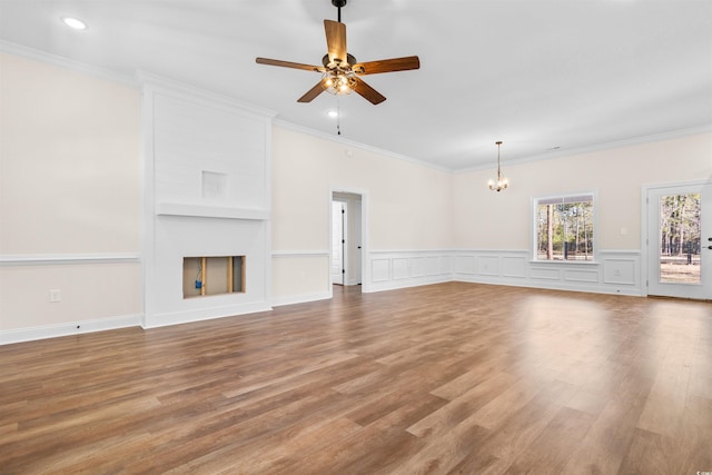 unfurnished living room featuring a fireplace, ornamental molding, ceiling fan with notable chandelier, and hardwood / wood-style floors