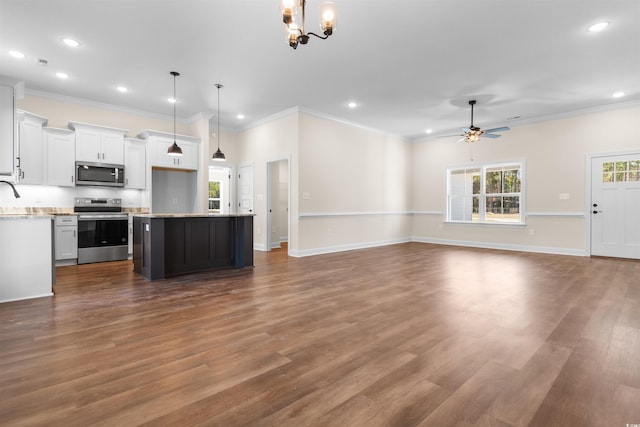 kitchen with white cabinets, a center island, stainless steel appliances, and decorative light fixtures