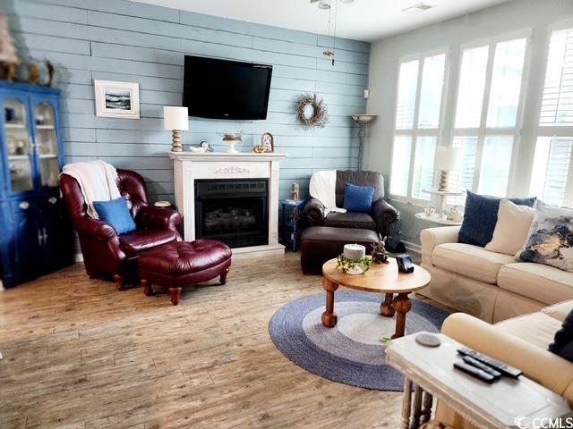 2256 Heritage Loop Unit 2256, Myrtle Beach, SC 29577 - living room featuring wood finished floors, wooden walls, and a fireplace with raised hearth