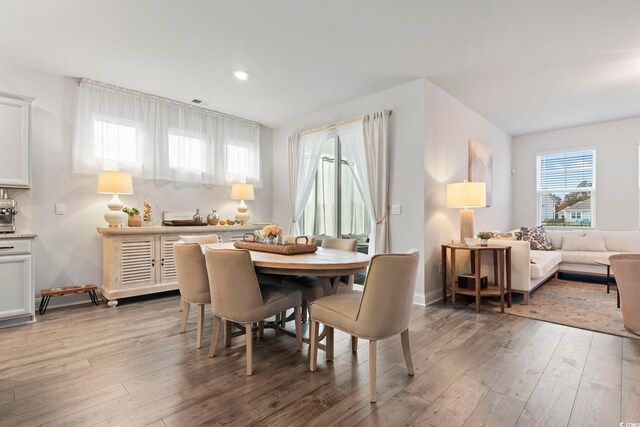 dining room featuring light wood-type flooring, baseboards, and recessed lighting