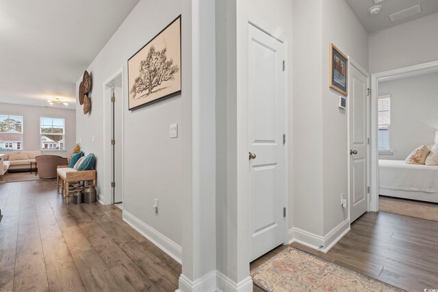 hallway featuring baseboards and hardwood / wood-style floors