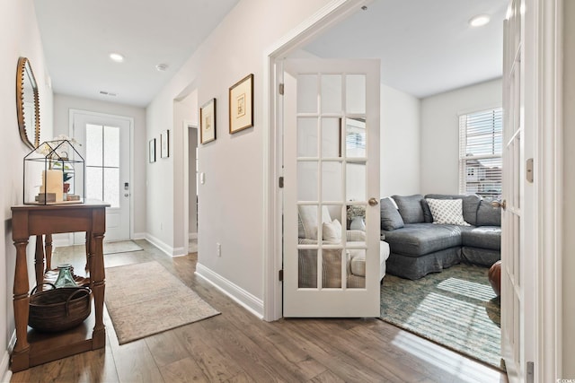 corridor featuring visible vents, baseboards, recessed lighting, and wood finished floors