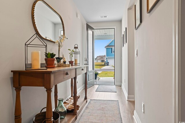 interior space with light wood-style floors, baseboards, and visible vents