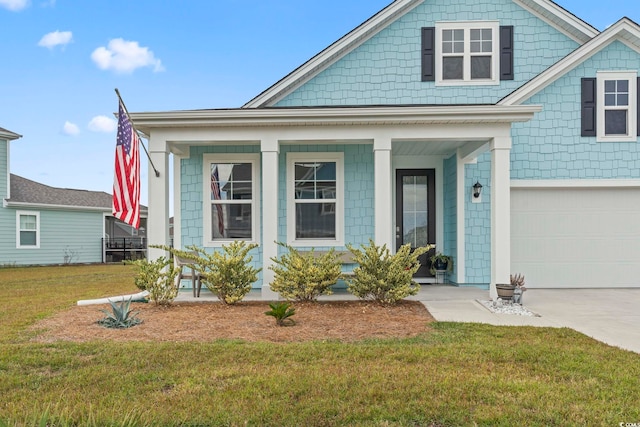 view of front of home with covered porch, a front yard, and a garage