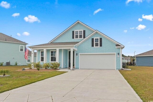 view of front of home with an attached garage, cooling unit, driveway, and a front lawn