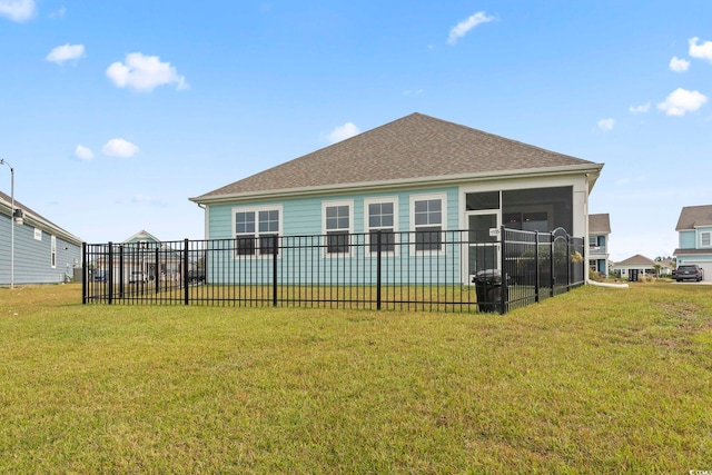 back of house with a yard, fence, a shingled roof, and a sunroom