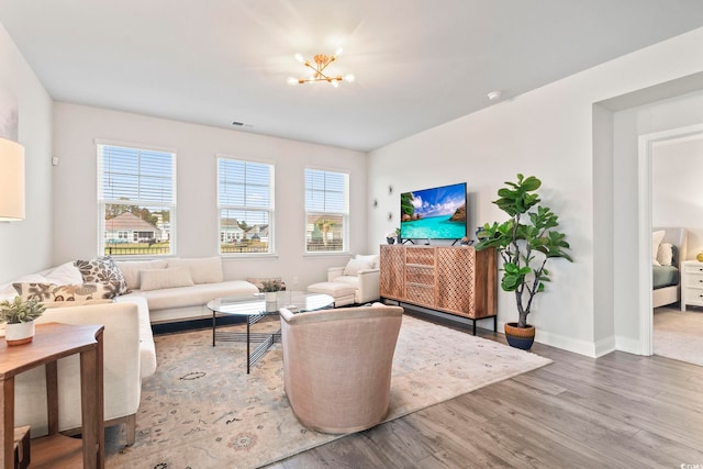 living room featuring a chandelier, wood finished floors, and baseboards