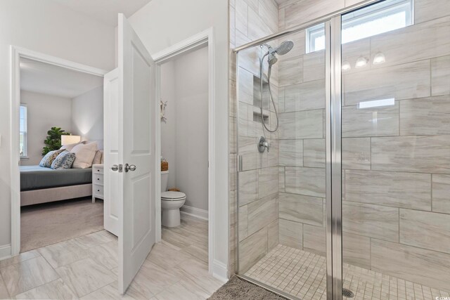 ensuite bathroom featuring toilet, a stall shower, a wealth of natural light, and connected bathroom