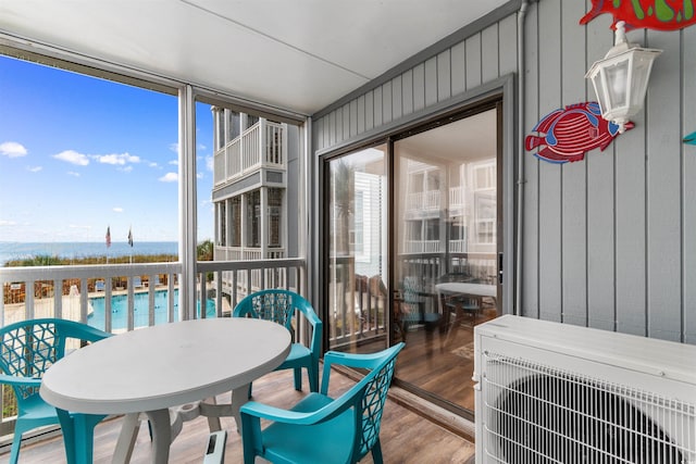 sunroom / solarium with ac unit and a water view