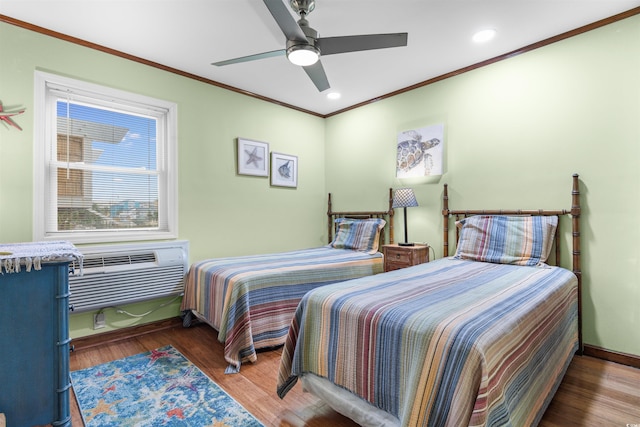 bedroom with hardwood / wood-style floors, an AC wall unit, ceiling fan, and crown molding