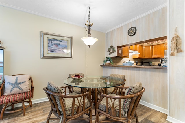 dining space featuring ornamental molding and hardwood / wood-style flooring