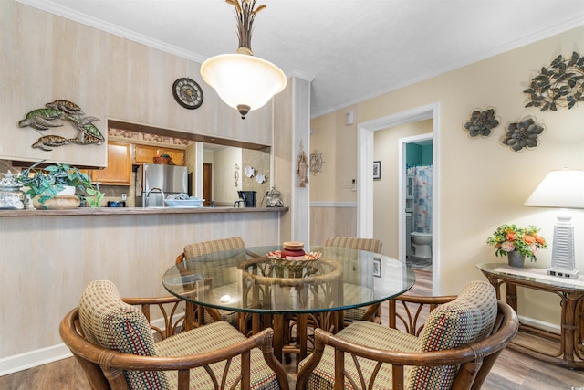 dining area featuring light hardwood / wood-style floors and crown molding