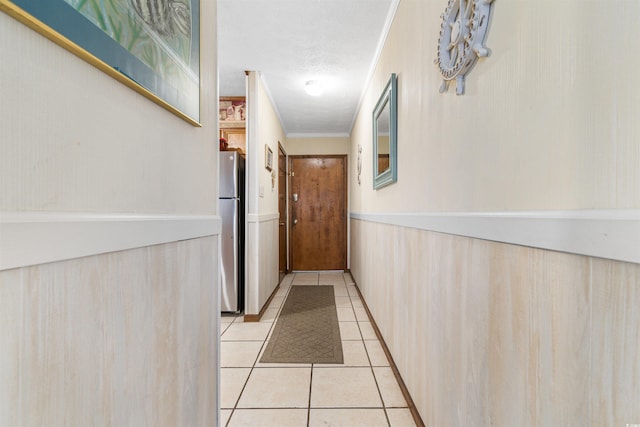 hallway featuring light tile patterned flooring and crown molding