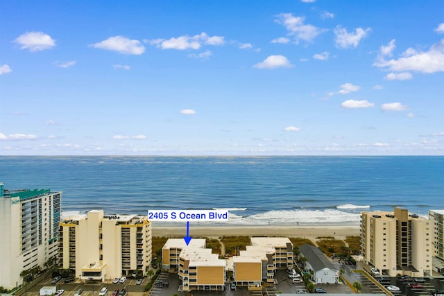 bird's eye view featuring a water view and a beach view