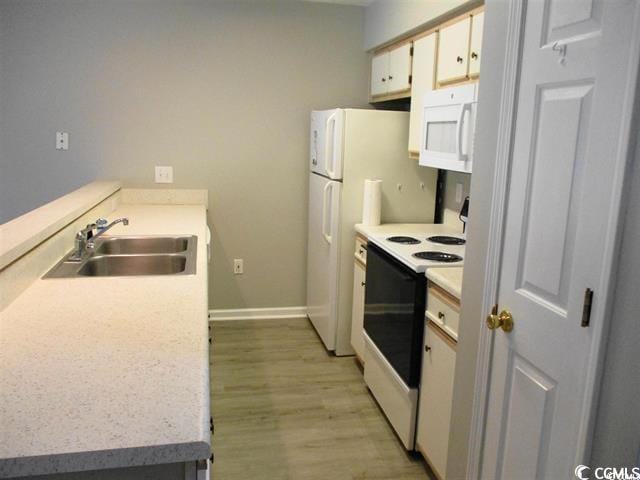 kitchen featuring white cabinets, white appliances, light hardwood / wood-style floors, and sink