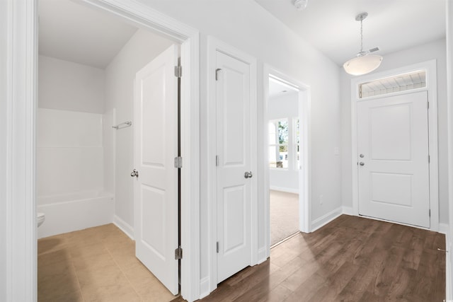 entryway featuring baseboards and dark wood-style flooring