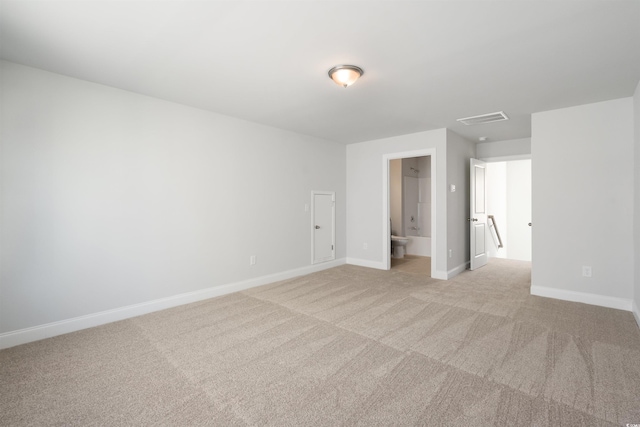 spare room with visible vents, light carpet, and baseboards