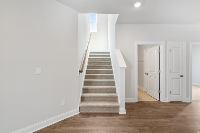 stairway with baseboards and wood finished floors