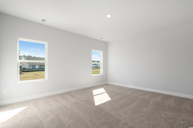 carpeted empty room featuring baseboards