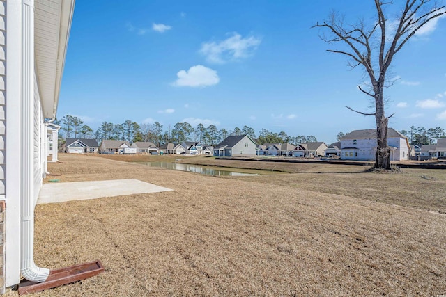 view of yard featuring a water view and a residential view