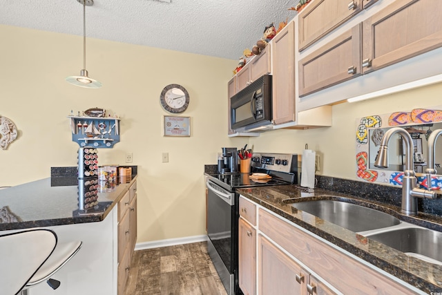 kitchen featuring dark hardwood / wood-style floors, sink, dark stone counters, hanging light fixtures, and electric range