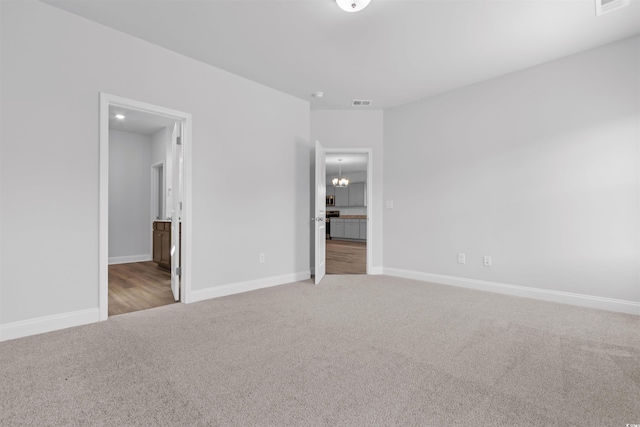 unfurnished bedroom with carpet and a notable chandelier