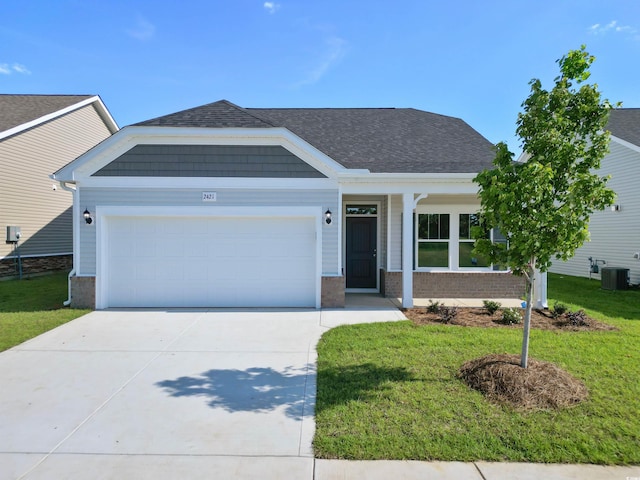 view of front of house featuring central air condition unit, a front lawn, and a garage