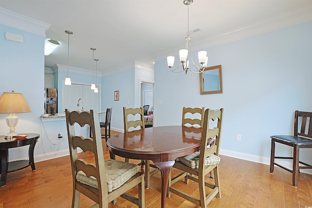 dining space featuring light hardwood / wood-style floors, crown molding, and a notable chandelier