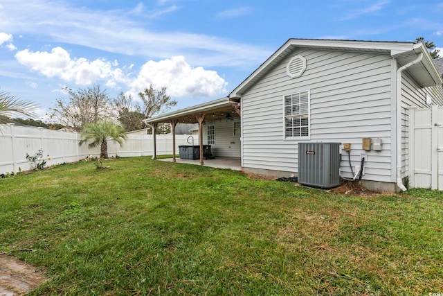 back of house with central AC, a yard, and a patio