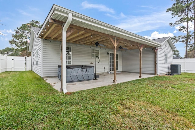 rear view of property with a patio area, a hot tub, central AC unit, a yard, and ceiling fan