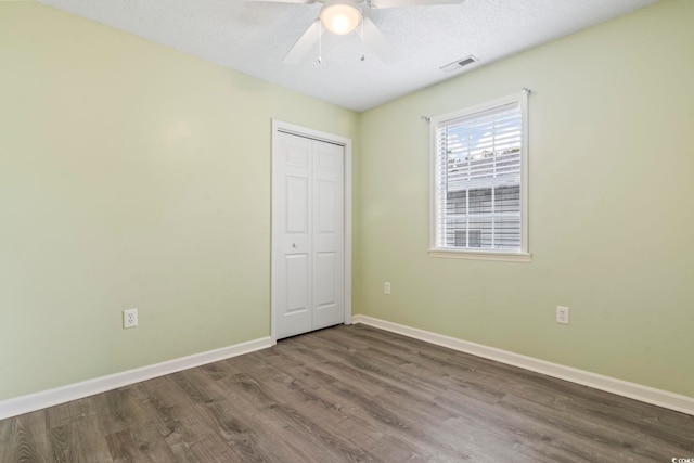 spare room with hardwood / wood-style flooring, ceiling fan, and a textured ceiling