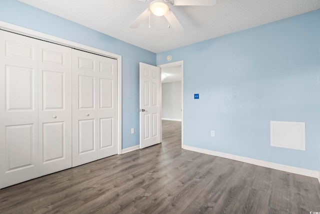 unfurnished bedroom with a closet, dark hardwood / wood-style floors, and ceiling fan